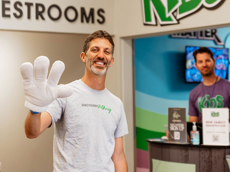 DC Kids volunteer holds out his hand with a big mitten