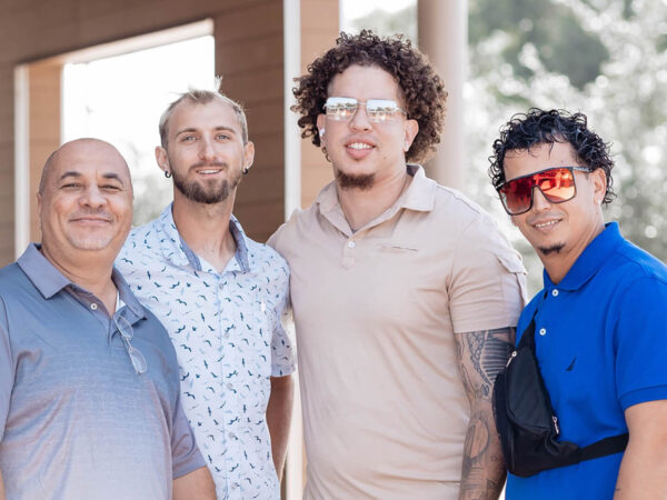 four men stand next to each other in a photo