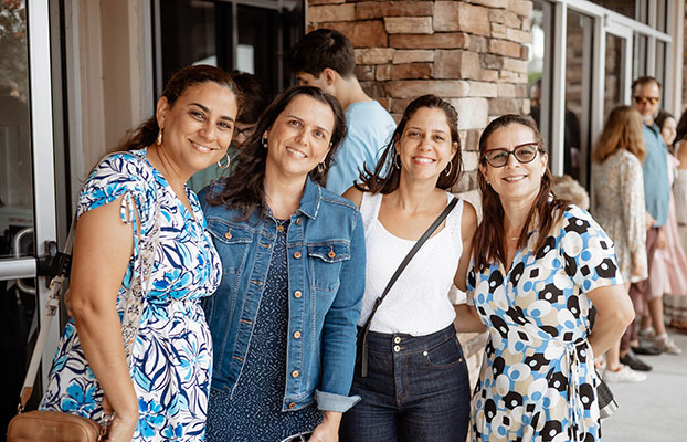 a group of four women standing outside pose for a photo at the Alafaya campus