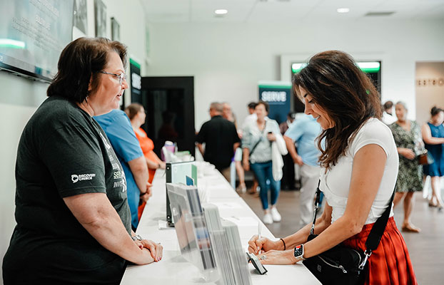 a young lady is at the info desk at the Winter Garden Campus